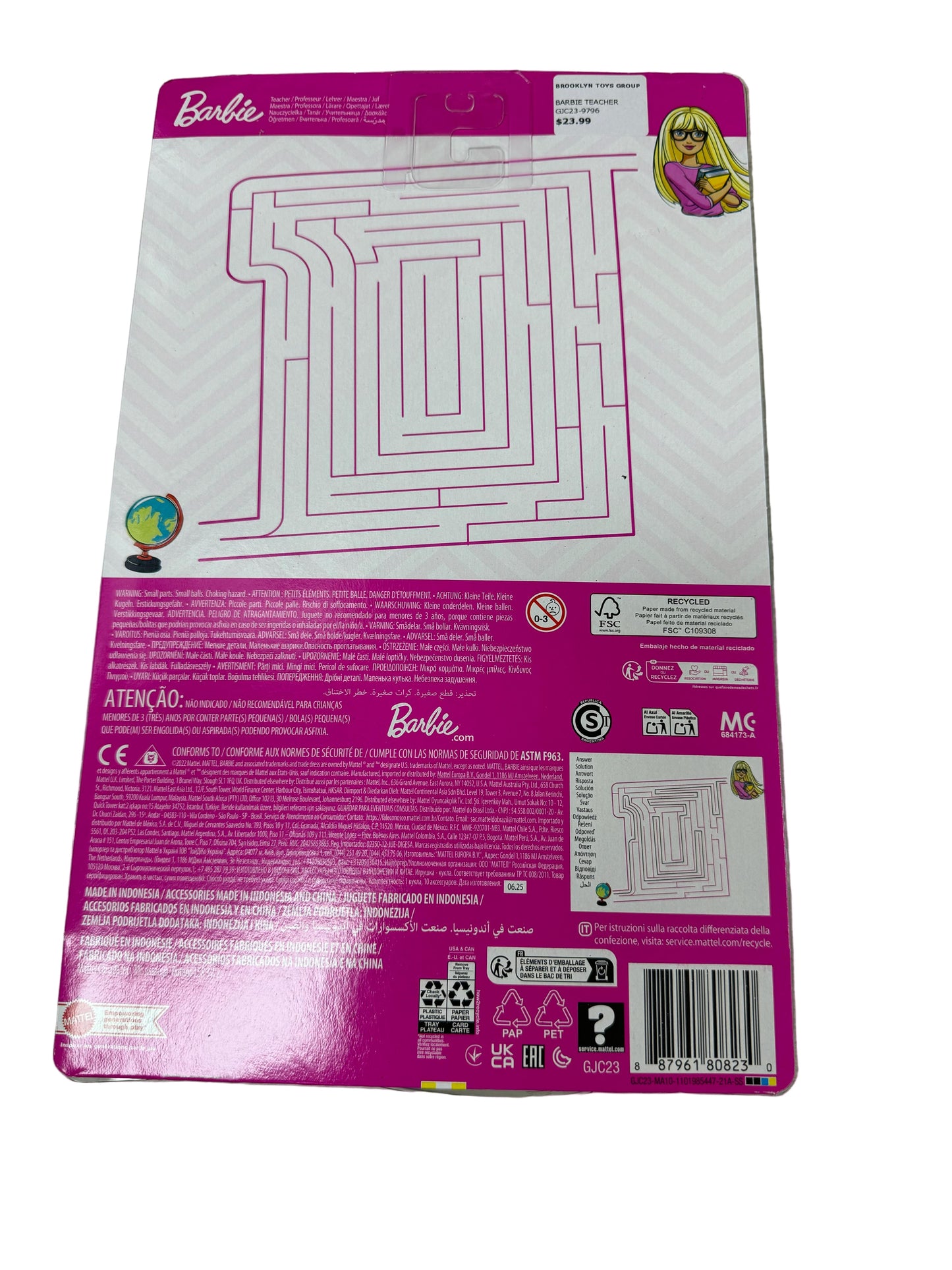 Back of a Barbie toy packaging with maze design on a wooden surface
