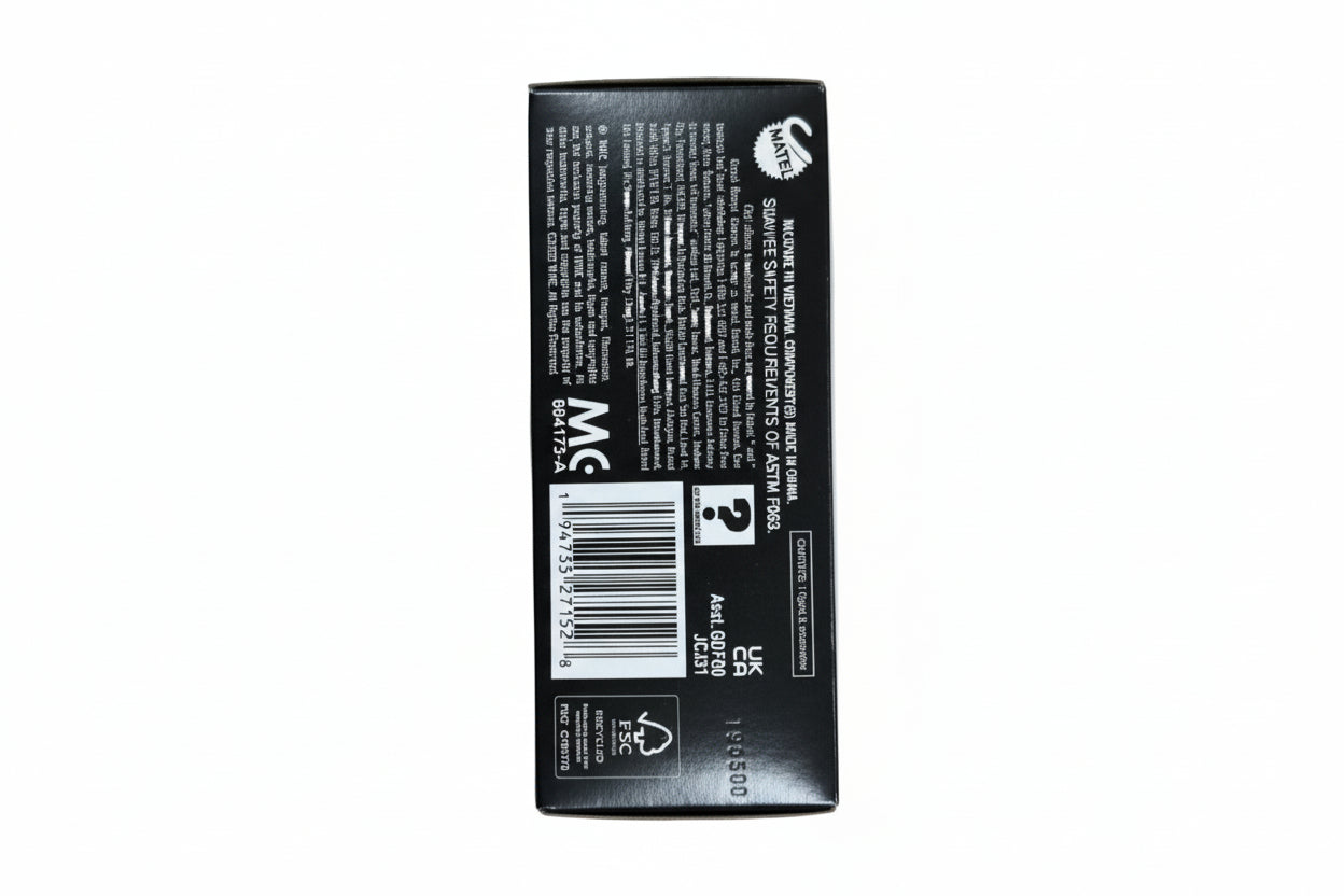 Hand holding a black rectangular box with text and a barcode on a light wooden surface