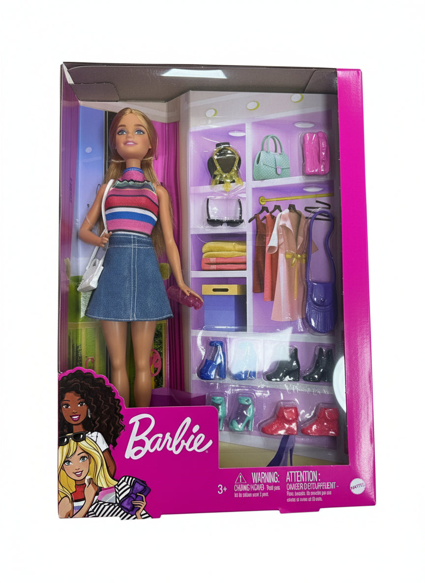 Barbie doll packaging with doll and accessories on a wooden surface