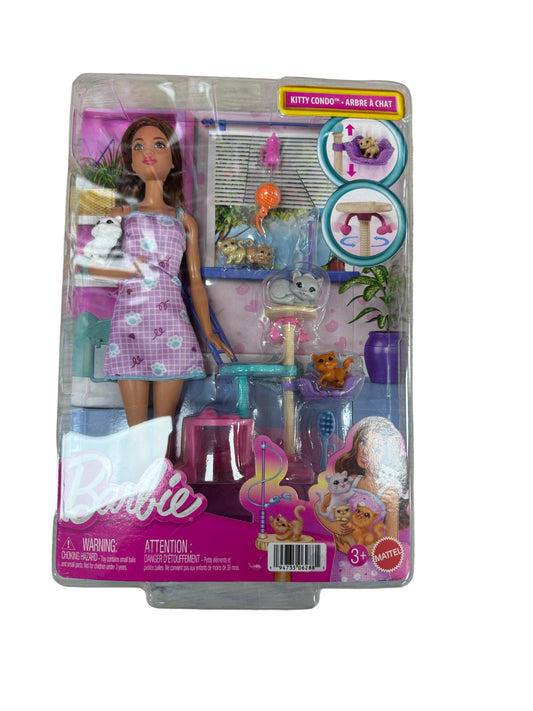 Barbie doll in packaging with accessories on a wooden surface