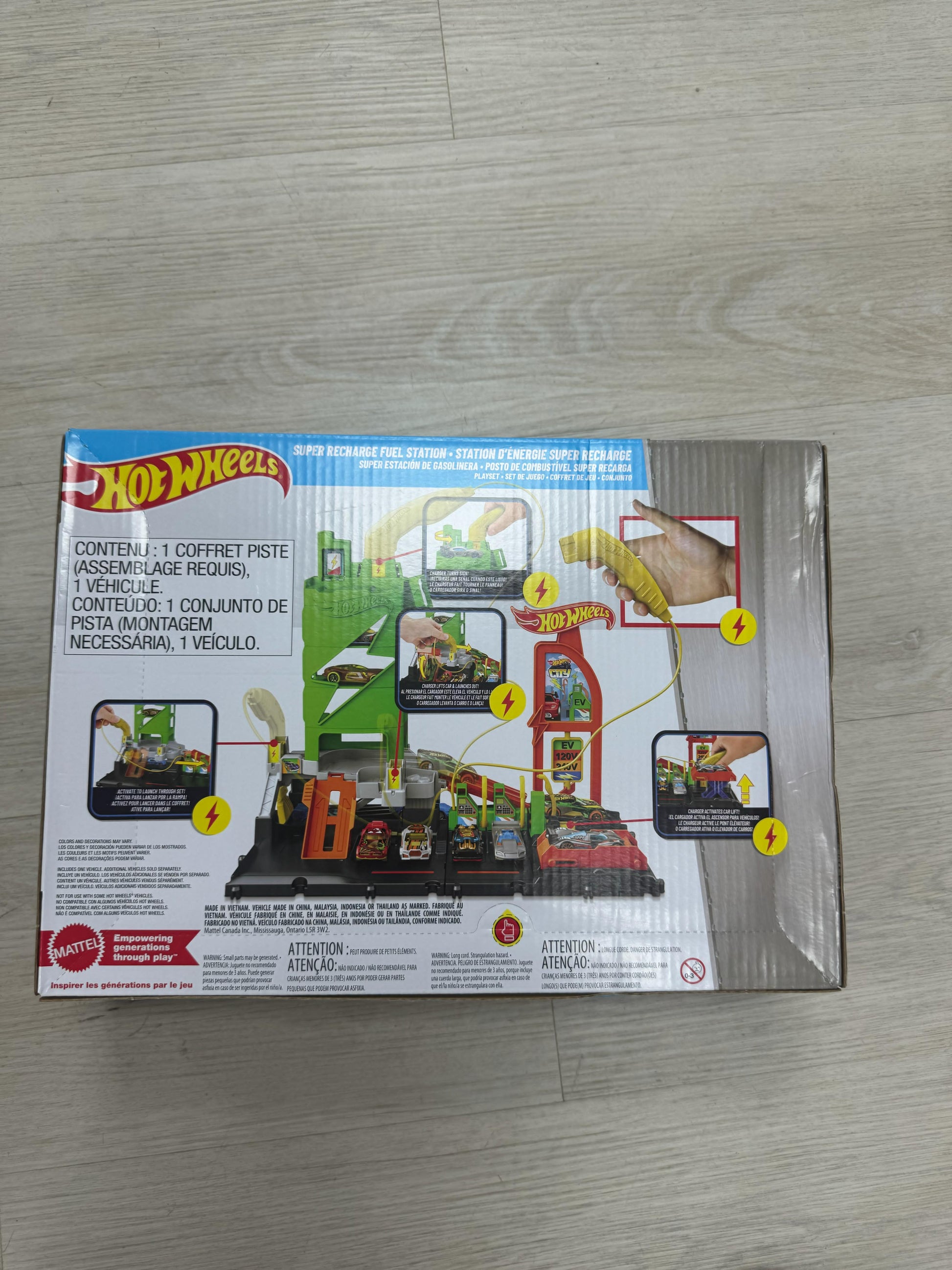 Hot Wheels toy set packaging on a wooden floor