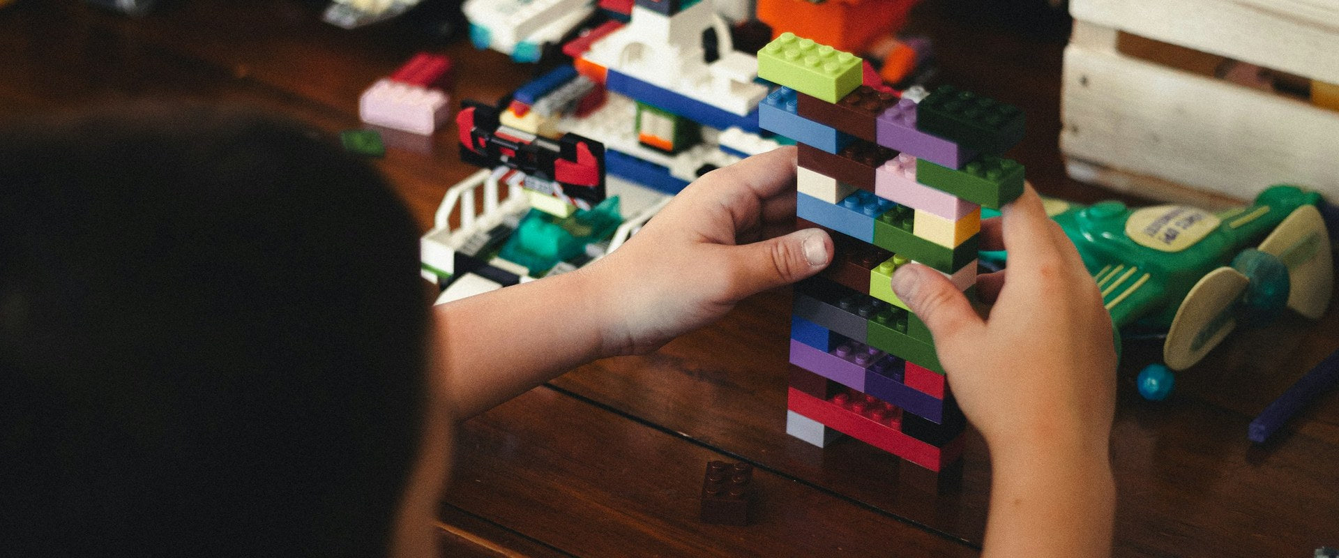 Child building with Lego bricks — Hero banner Lego