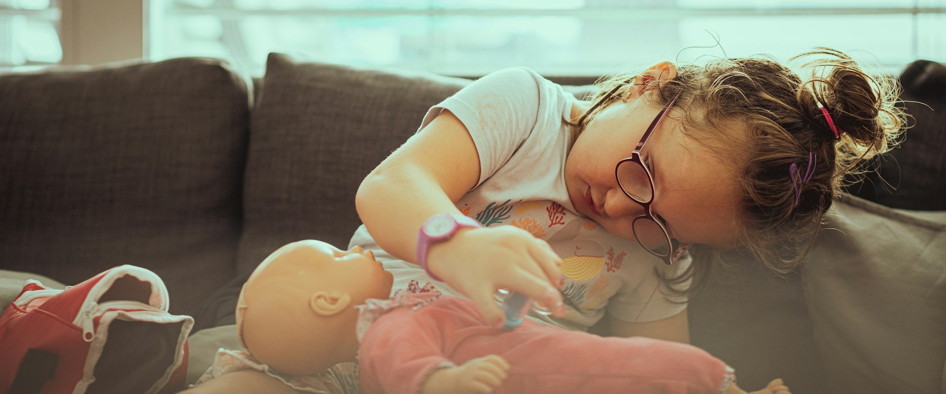 Girl playing with doll on couch — Hero banner Barbie