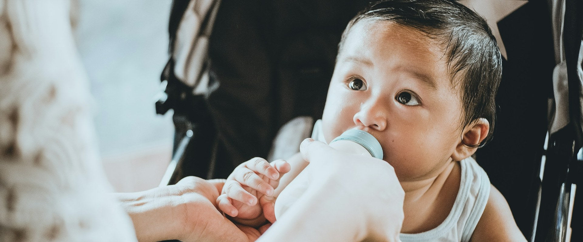 Baby with feeding bottle — Hero banner Baby Formulas